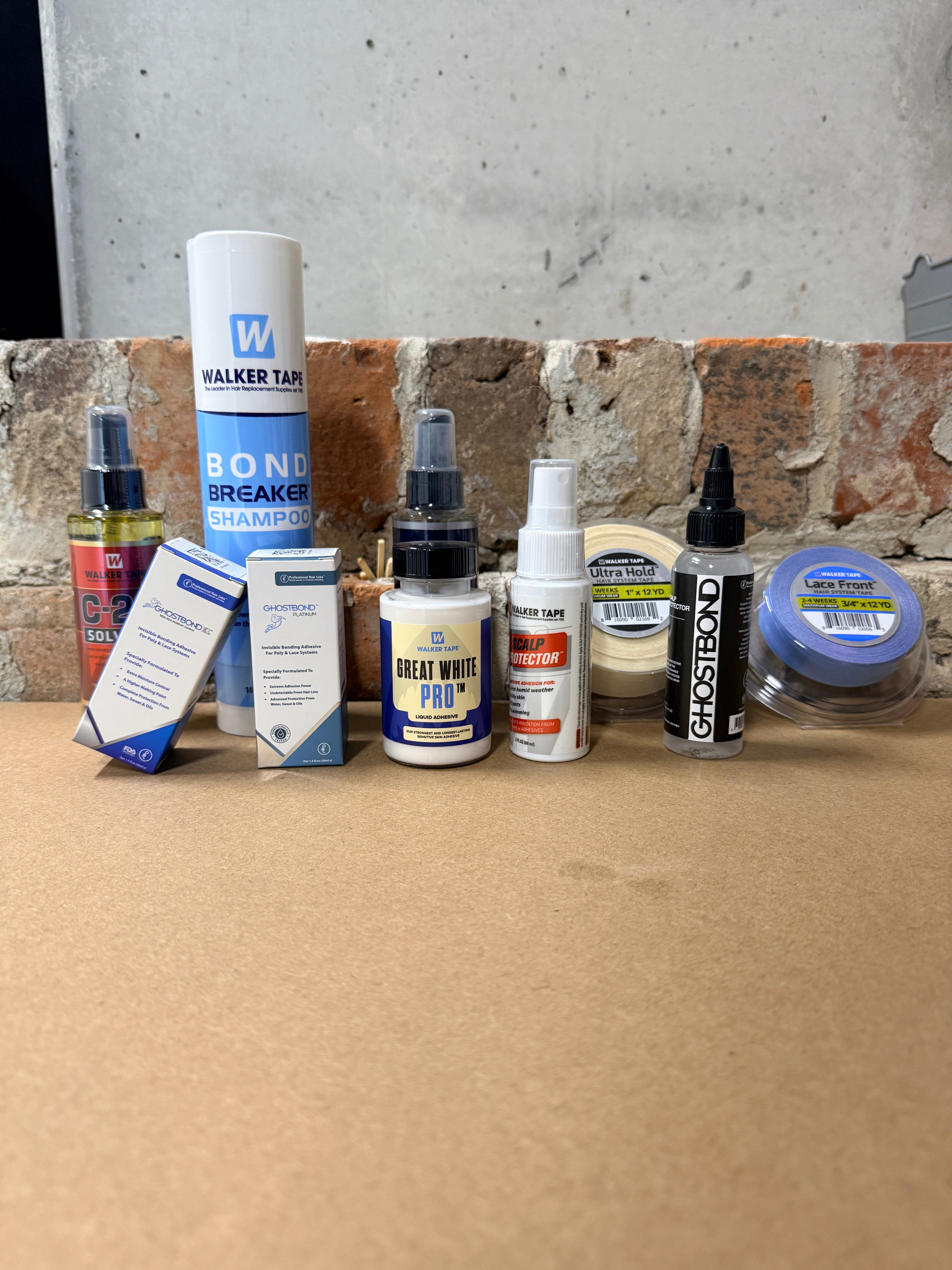 Collection of small bottles and containers on a concrete surface with a cardboard box.
